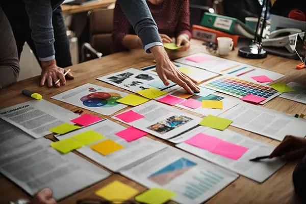 Unser Team steht am Tisch und bespricht die Planung des Projektes